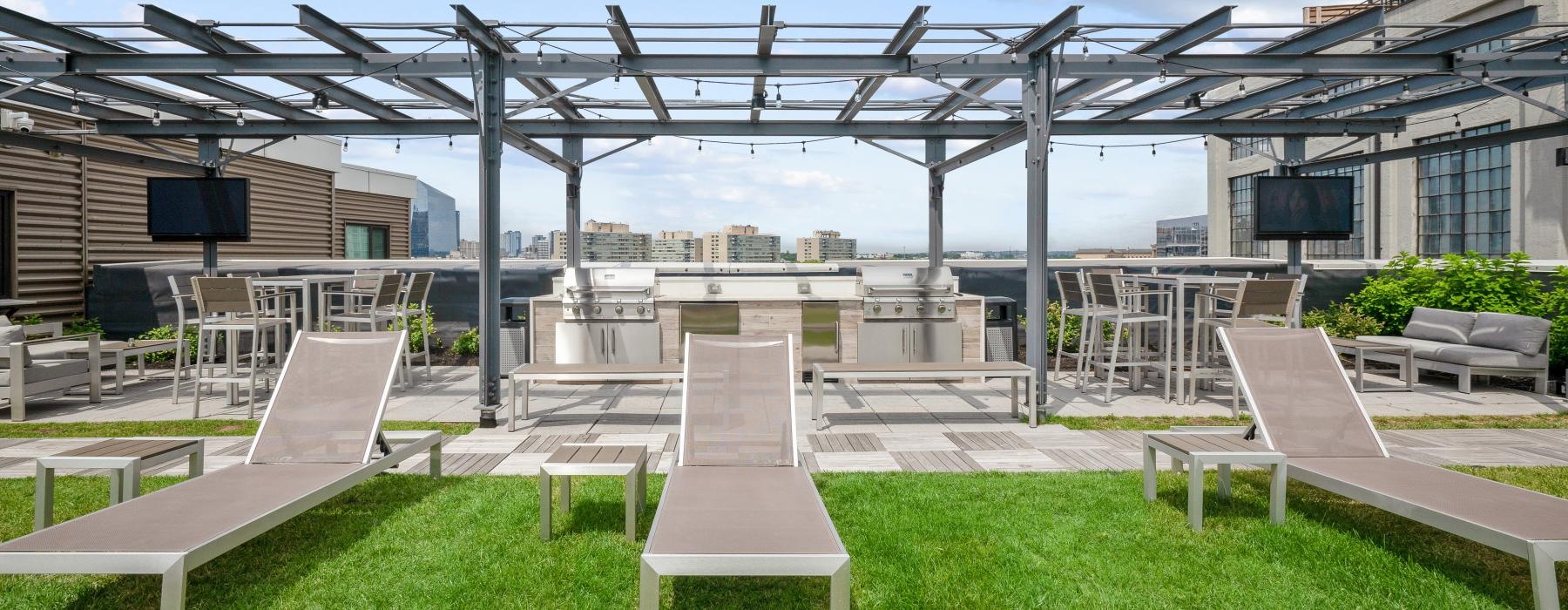 Outdoor patio with grills, dining areas and lounge chairs at The Granary's Logan Square apartments