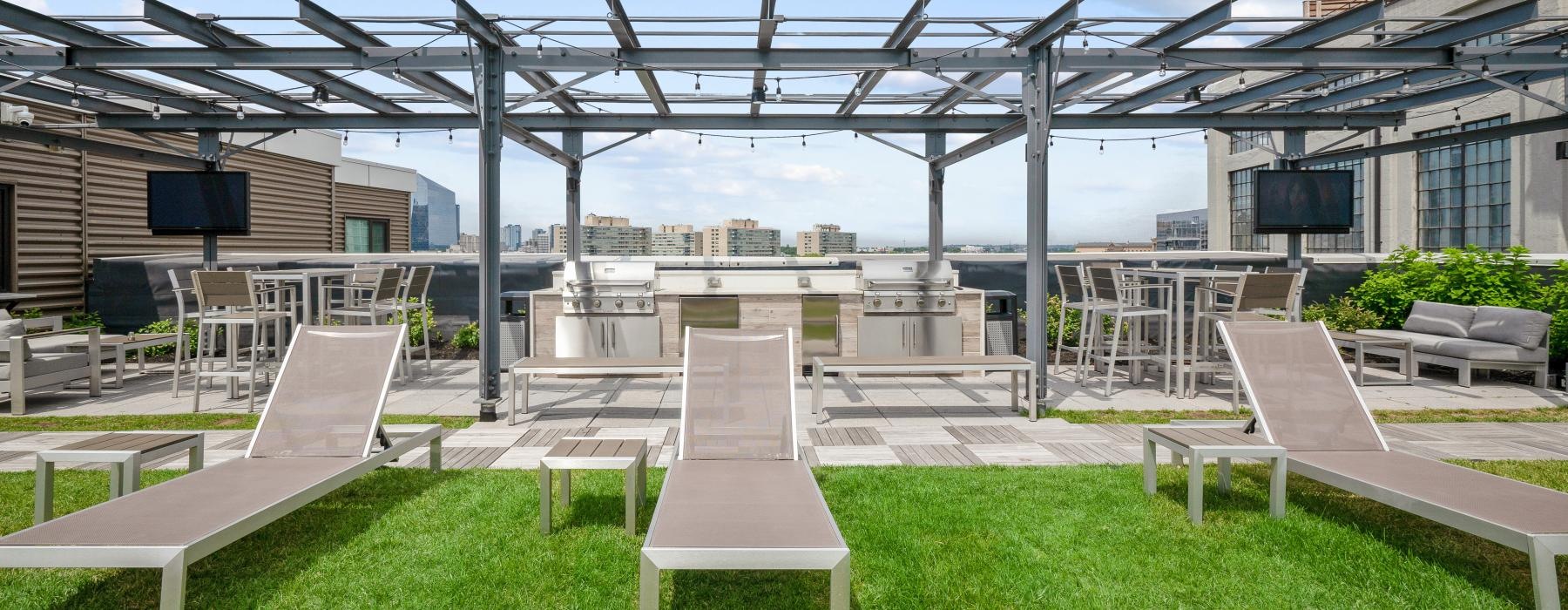 a patio with seating grass and grills