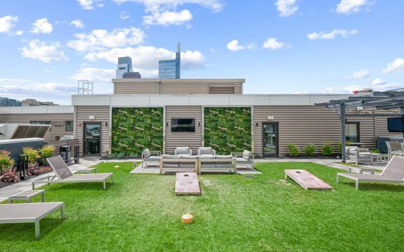 a patio with a lawn benches and corn hole